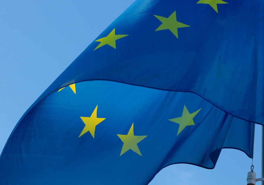 The blue EU flag with its yellow stars waving in the wind
