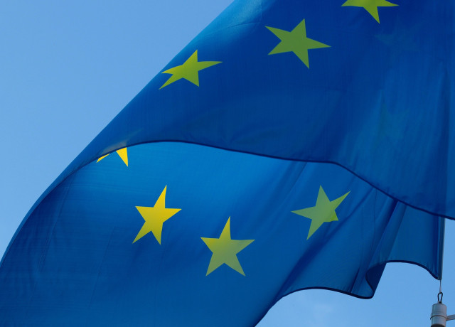 The blue EU flag with its yellow stars waving in the wind